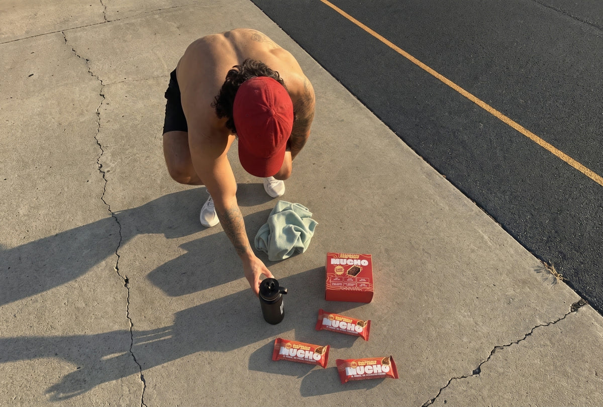 Athlete holding a Mucho protein bar in the gym