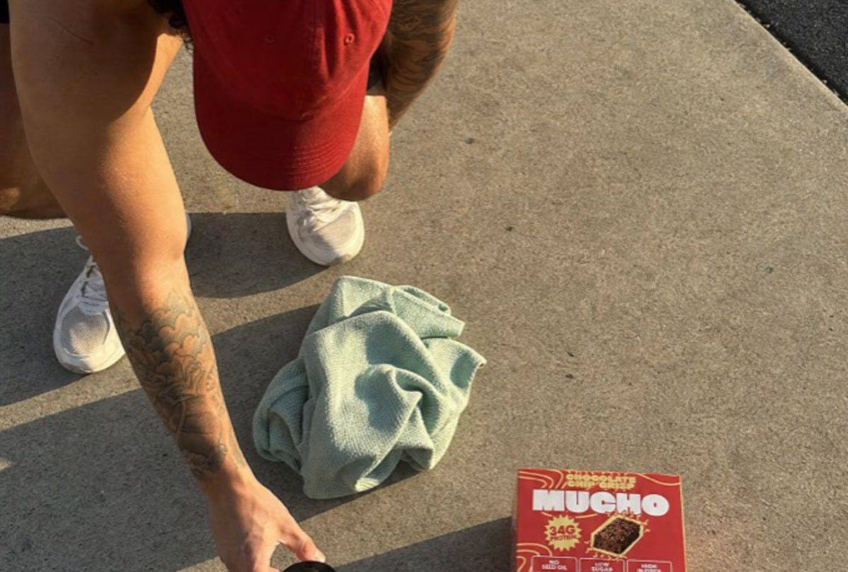 Athlete holding a Mucho protein bar in the gym