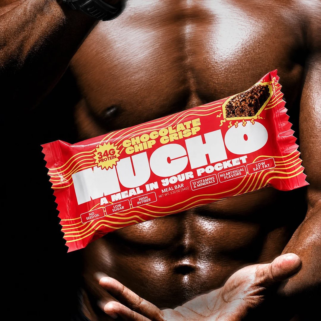 Muscular athlete with a Mucho Chocolate Chip Crisp bar floating between his hands