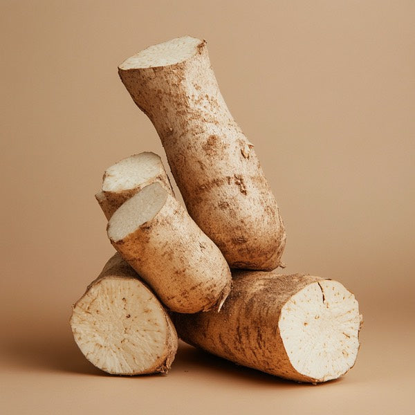 Cut pieces of tapioca root stacked against a brown background.