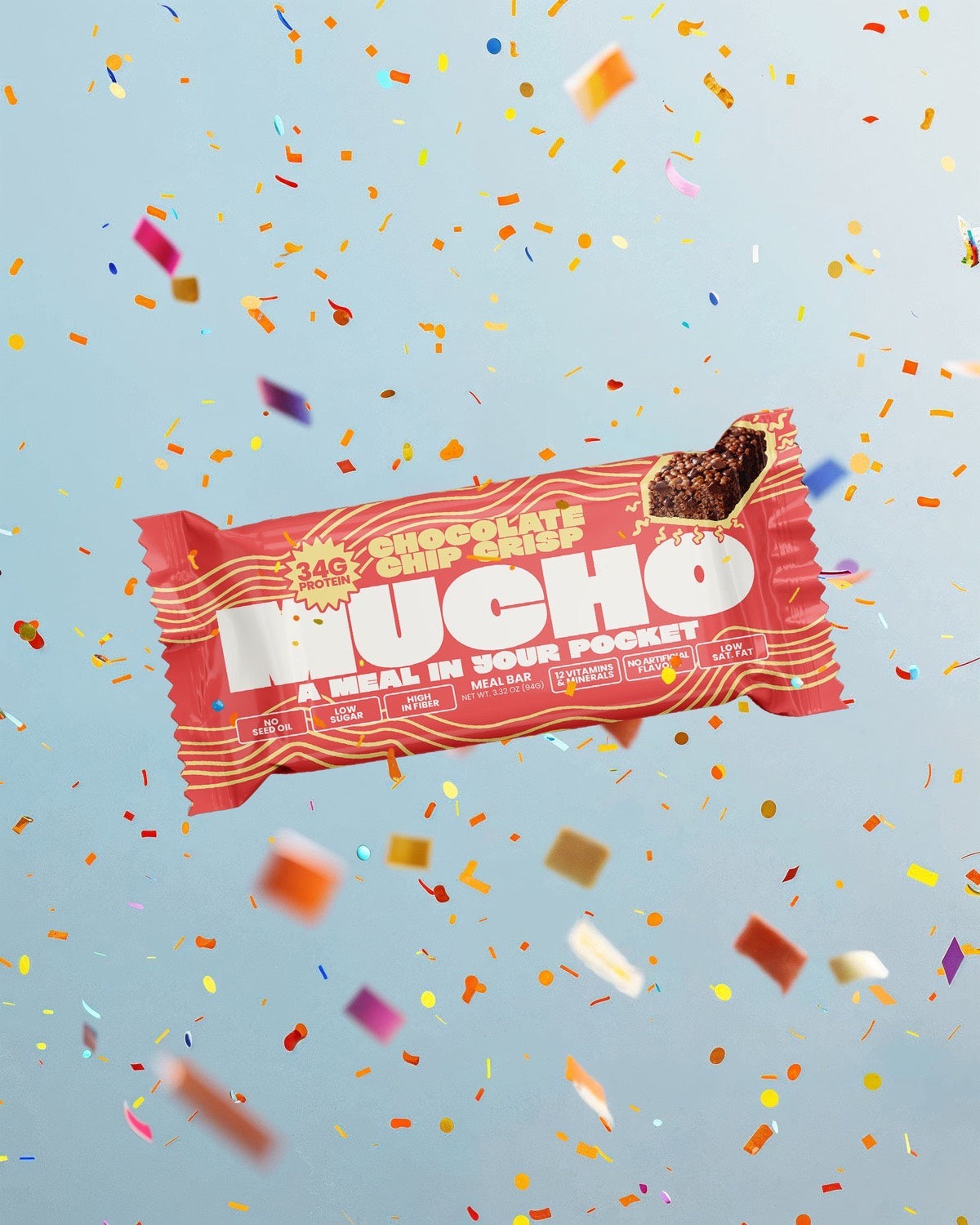 A Mucho Meal Bar held in front of a stack of the Chocolate Chip Crisp boxes.
